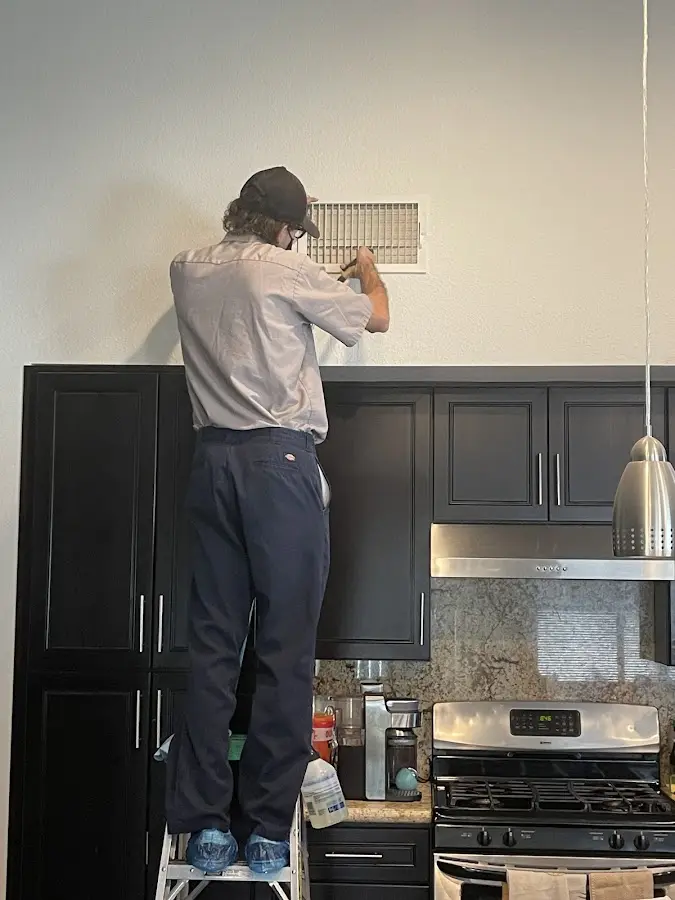 Technician inspecting an air vent during HVAC service in Lauderdale Lakes